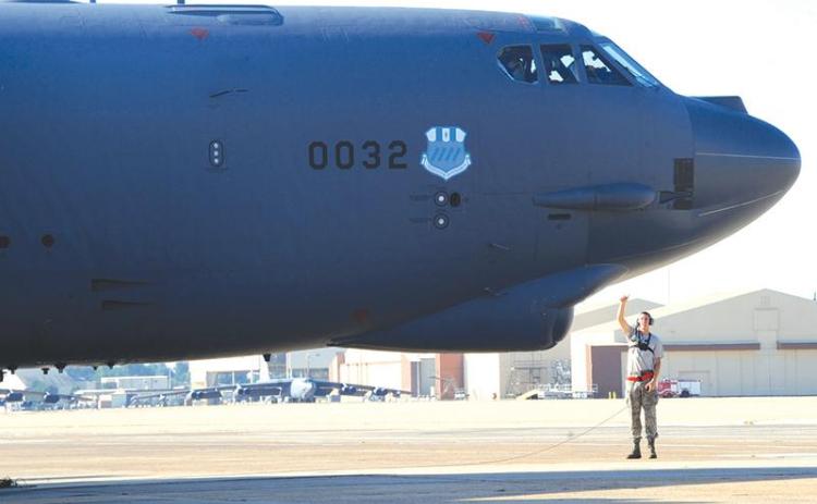 Senior Airman Mitchell Dexter, 2nd Aircraft Maintenance Squadron crew chief, communicates with aircrew in the cockpit of a B-52H Stratofortress during a Minimum Interval Takeoff on Barksdale Air Force Base, La., Aug. 14, 2014. A MITO is executed to allow the B-52 to quickly respond and deliver precision munitions at a moment’s notice. Starter cartridges, filled with gun powder, are used during this takeoff instead of the standard, compressed-air takeoff. (U.S. Air Force photo/Staff Sgt. Sean Martin)