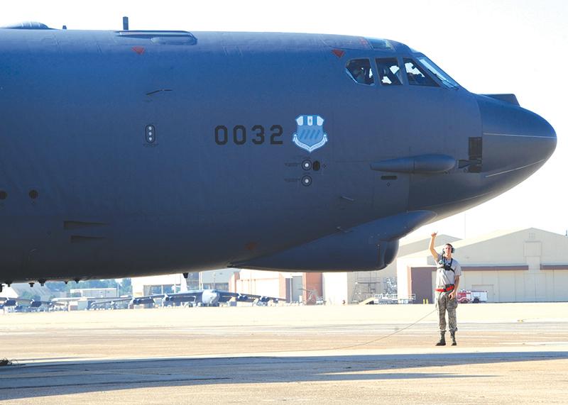 Senior Airman Mitchell Dexter, 2nd Aircraft Maintenance Squadron crew chief, communicates with aircrew in the cockpit of a B-52H Stratofortress during a Minimum Interval Takeoff on Barksdale Air Force Base, La., Aug. 14, 2014. A MITO is executed to allow the B-52 to quickly respond and deliver precision munitions at a moment’s notice. Starter cartridges, filled with gun powder, are used during this takeoff instead of the standard, compressed-air takeoff. (U.S. Air Force photo/Staff Sgt. Sean Martin)