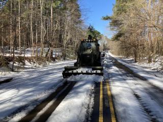 National Guard personnel clear an ice-covered road intersecting Firetower Rd. near Rocky Mount Monday.